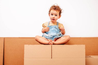 Kız tek başına komik ifadelerle karton kutularda oynuyor..