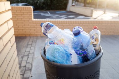 Valencia, İspanya - 4 Ağustos 2020: Birçok plastik şişe bir çöp kutusunda taşmaktadır. Gerekli şekilde dönüştürülemeyecek materyal.