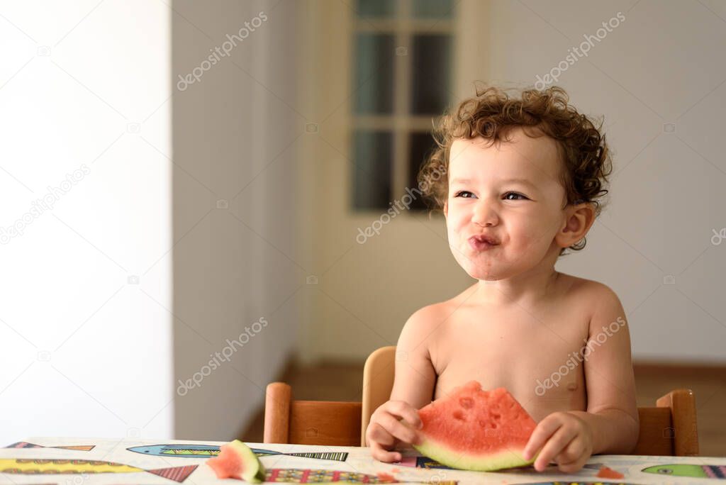 Funny adorable little girl with humorous expression during meal.