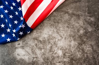 Çarpıcı renkli Amerikan bayrağı taştan gri bir arka planda bir köşede izole edilmiş..