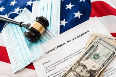 Coronavirus salgını sırasında ödenmemiş ödemeler için tahliye ihbarı, maskeli ve Amerikan bayrağı olan belgeler.