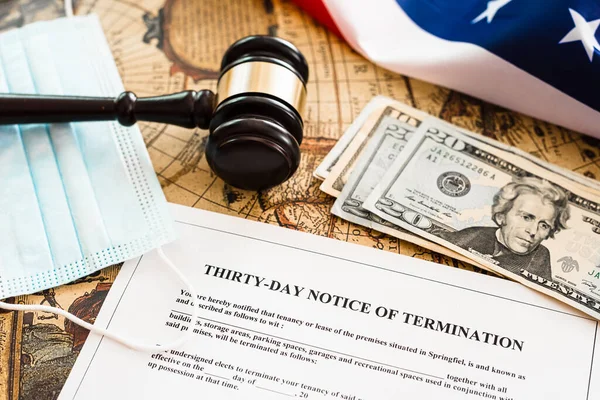Amerikan bayrağının arka planında, dolar ve hijyenik maskelerle birlikte 30 günlük fesih bildirimi belgesi.