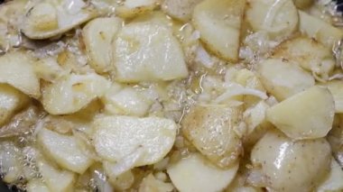 Patates ve sarımsaktan yapılmış tipik bir İspanyol yemeği, tavada zeytinyağıyla kızartılmış, yukarıdan görülüyor.