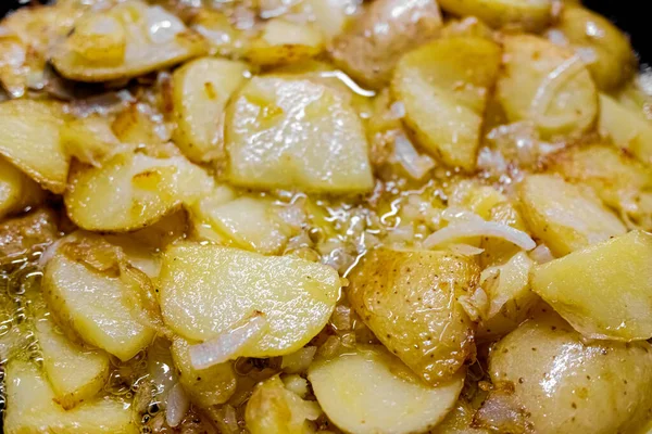 Patates ve sarımsaktan yapılmış tipik bir İspanyol yemeği, tavada zeytinyağıyla kızartılmış, yukarıdan görülüyor.