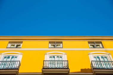 Tipik bir Akdeniz binasının parlak cephesi parlak renkler ve sıcak tonlarla boyanmış..