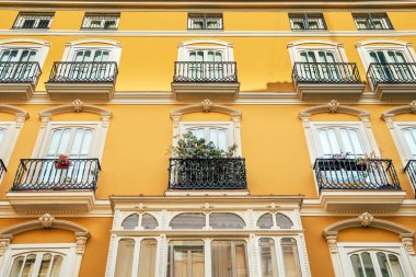 Tipik bir Akdeniz binasının parlak cephesi parlak renkler ve sıcak tonlarla boyanmış..