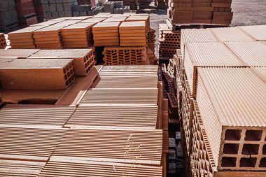 İnşaat malzemeleri deposuna duvar örmek için yığılmış tuğla yığını..