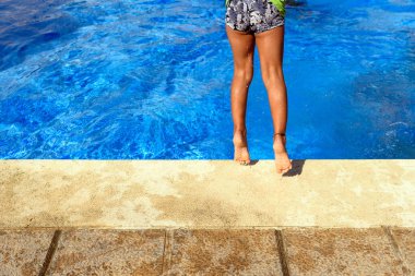 Yazın son günlerinde güneşin altında havuzda eğlenen bir çocuk..