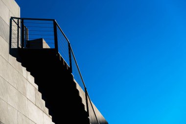 Modern taş merdivenlerin üst basamaklarında gölgeler olan minimalist bir duvar..