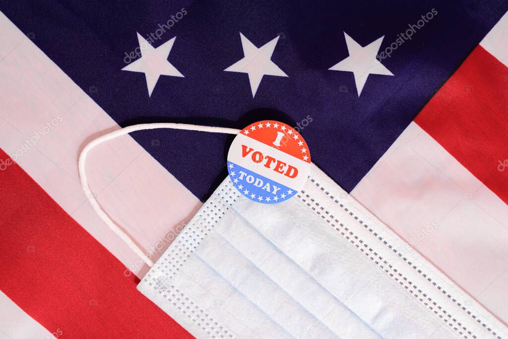 Face mask of a proud voter during the democratic elections in the USA with stickers on the patriotic American flag.