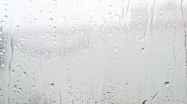 Soğuk bir kış gününde açık camların önünde yağmur yağıyor.