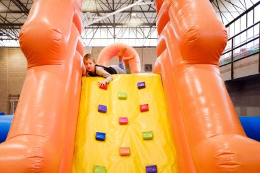 Bir çocuk doğum günü partisinde şişme bir şatoda zıplayıp zıplamaktan hoşlanır..