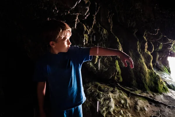 ぬれた洞窟の中を探検する子供 — ストック写真