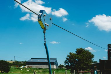 Çocuk oyunu için tasarlanmış, sağlam yapısını gösteren bir makara makarasının yakın çekimi. Sakin bir kırsal alan, serin bir zemin görevi görerek, açık hava macera atmosferine katkı sağlıyor..