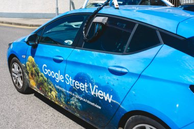 Google Street View için donatılmış parlak mavi bir araç, sualtı manzaralarının canlı grafiklerini gösterirken şehir sokaklarının ayrıntılı görüntülerini yakalıyor.