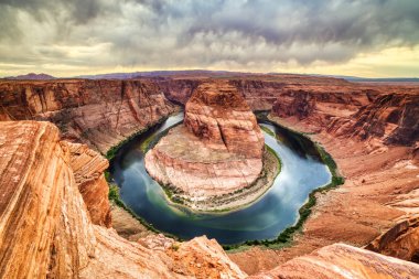 At nalı Bend batımında dramatik ile bulutlu Colorado Nehri üzerinde 