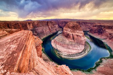 At nalı Bend batımında dramatik ile bulutlu Colorado Nehri üzerinde 