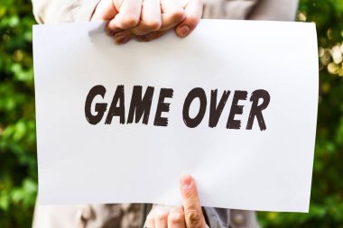 Kadın elinde bir kağıt tutuyor, oyun bitti.