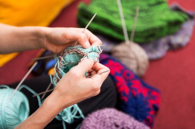 Yün ve iğnelerle işçilik yapan ellere yakın çekim