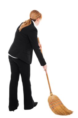 Elinde süpürge olan bir iş kadını etrafı temizliyor.