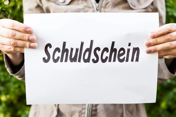 Vrouw Houdt Een Krant Met Duits Woord Schuldschein Betekent Schuld — Stockfoto
