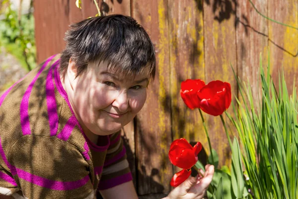 Mentally Disabled Woman Smells Flower — Stock Photo, Image