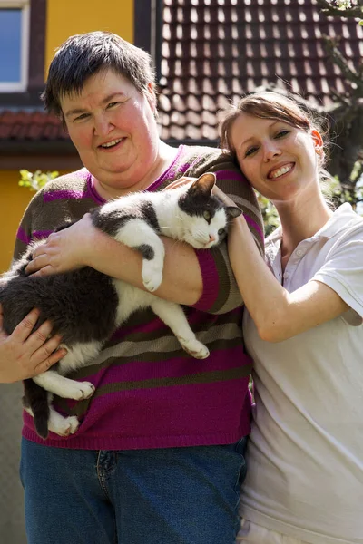 Disabled Woman Holding Cat Female Caregiver Background — Stock Photo, Image