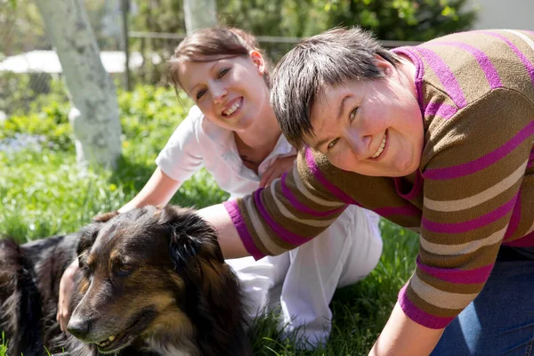两个女人在田里喂狗 — 图库照片