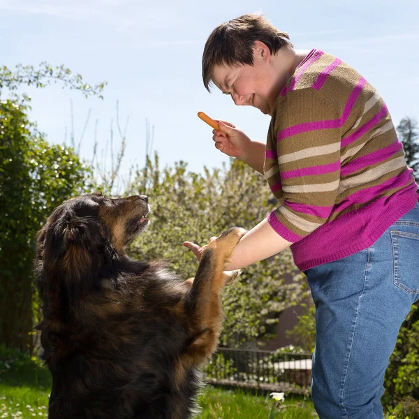 Mulher Com Deficiência Mental Está Alimentando Cão — Fotografia de Stock