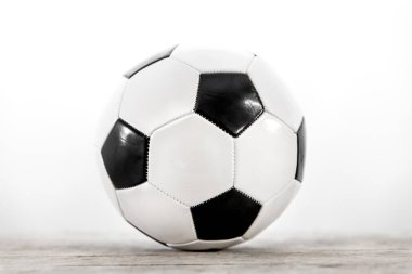 Beyazların önündeki tahta bir masada futbol topu.
