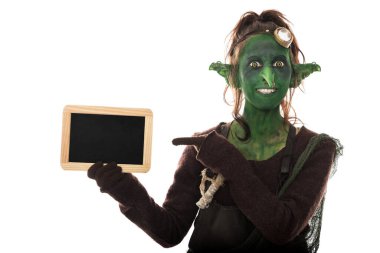 Komik dişi goblin, beyaz üzerine izole edilmiş bir boşluğu işaret ediyor.