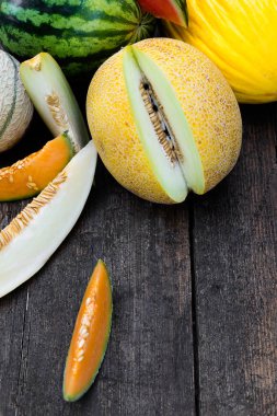 Bir sürü taze ve dilimlenmiş karpuz ve koyu ahşap arka planda üst görünüm