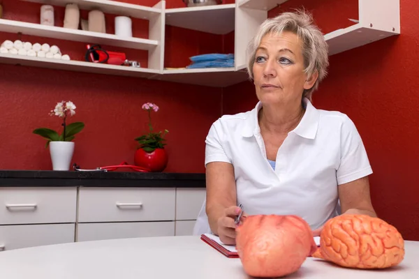 Internista Feminina Pensa Algo Seu Escritório Coração Plástico Cérebro Uma — Fotografia de Stock