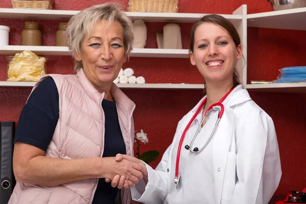Mladá Žena Lékař Dává Starému Pacientovi Stisk Ruky Červená Kancelář — Stock fotografie