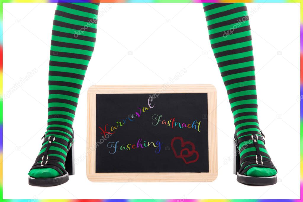 witch or goblins green and black striped legs, slate with german words for carnival isolated on white
