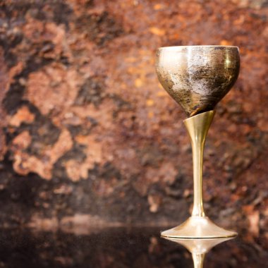 Paslı arka planda eski ortaçağ pirinç bardağı