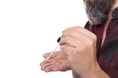 Yaklaş, eline sakal yağı döken adam, hippiler için sakal bakımı ürünü, beyazların üzerine izole edilmiş.