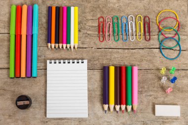 Not defteri, kalem ve diğer ekipmanlarla dolu renkli ofis masası, ahşap masa, düz uzanma.