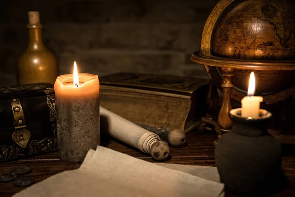 两个羊皮纸 一个旧地球仪和蜡烛 一本旧书和一个木箱 中世纪背景的概念 — 图库照片