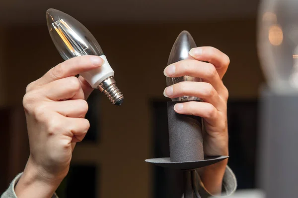 closeup, woman changing a light bulb, energy saving lamp, electrictiy