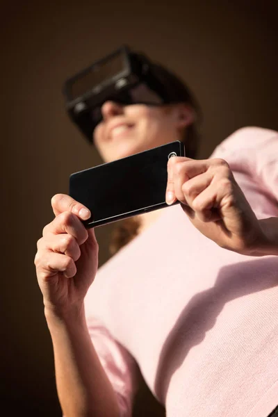 Kobieta Kontroluje Swoje Okulary Wirtualnej Rzeczywistości Pomocą Smartfona — Zdjęcie stockowe