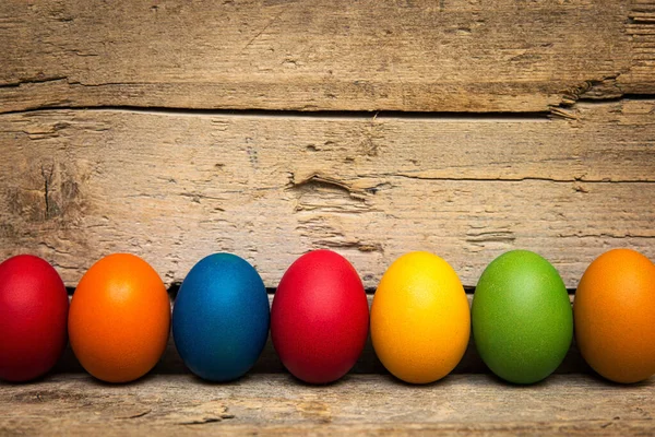 Una Fila Coloridos Huevos Pascua Frente Fondo Madera Imagen de archivo