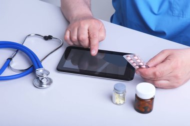 Doktor bir blister haplarla elinde tutuyor ve çalışma alanı'na yakın çekim reçete yazıyor. reçete ilaç, yasal eczane deposu, hastalıkların tedavisinde
