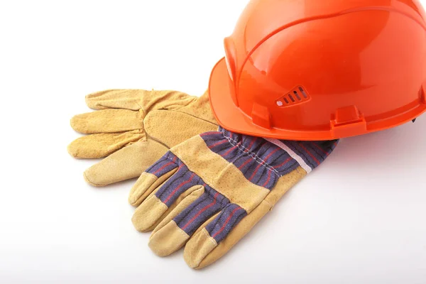 Orange hard hat, safety gloves on white background. Safety helmet.