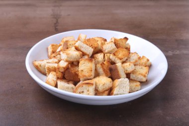 Lezzetli çıtır kruton, beyaz tabak içinde ekmek kırıntıları. hazır yemek pişirmek için.