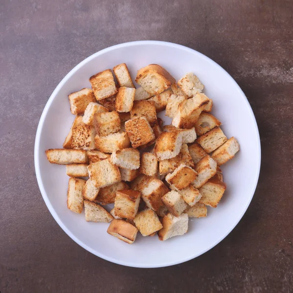 Delicious crispy croutons, crumbs of bread in white plate. ready for cooking. — Stock Photo, Image