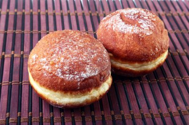 Jöle ile ev yapımı çörek dolu ve pudra şekeri bambu masa örtüsü üzerinde. Seçici odak.