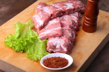 Tuz, biber ve baharat değirmeni ile bir rustik kesme tahtası üzerinde ham kaburga. kopya alanı. Üstten Görünüm.