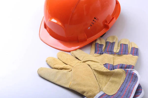 Oranžový tvrdý klobouk, brýle a bezpečnostní rukavice na bílém pozadí. — Stock fotografie