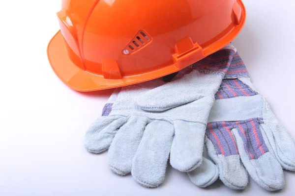 Beyaz bir arka planda turuncu zor şapka, gözlük ve emanet eldiven.